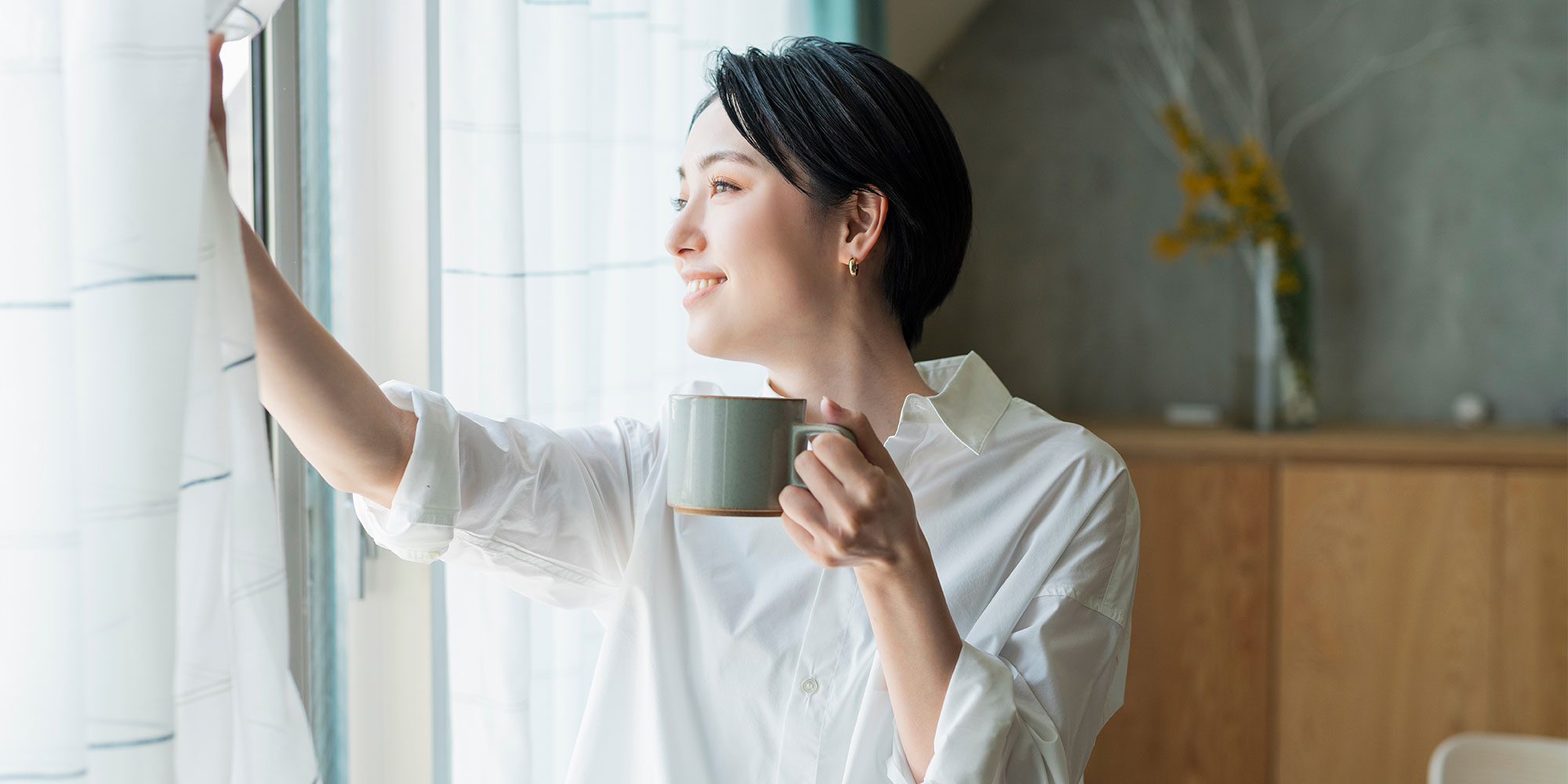 カーテンを開ける女性