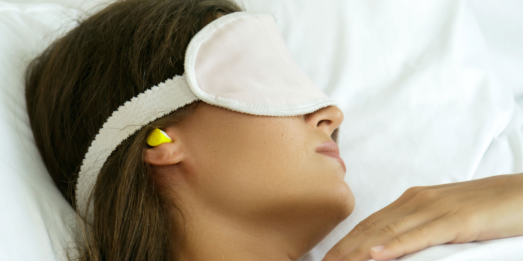 耳栓とアイマスクをして眠る女性