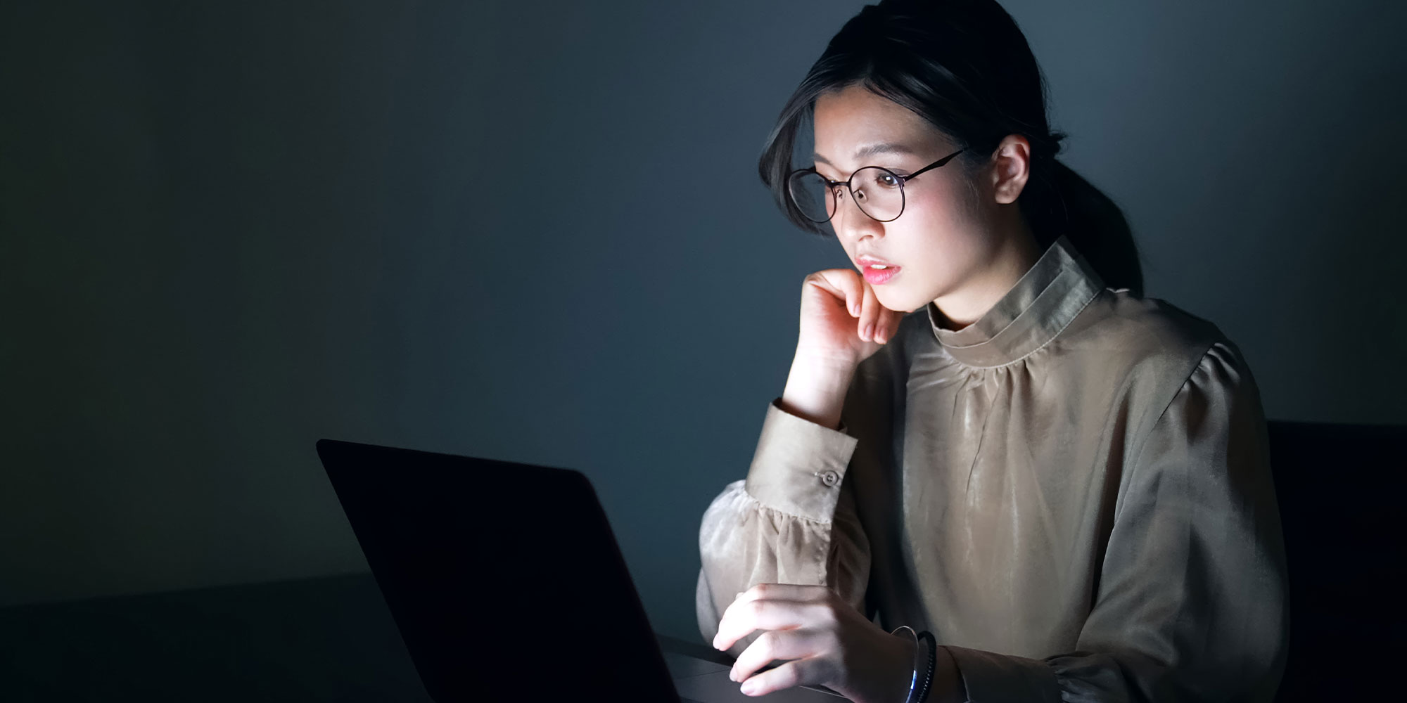 夜パソコンを触る女性