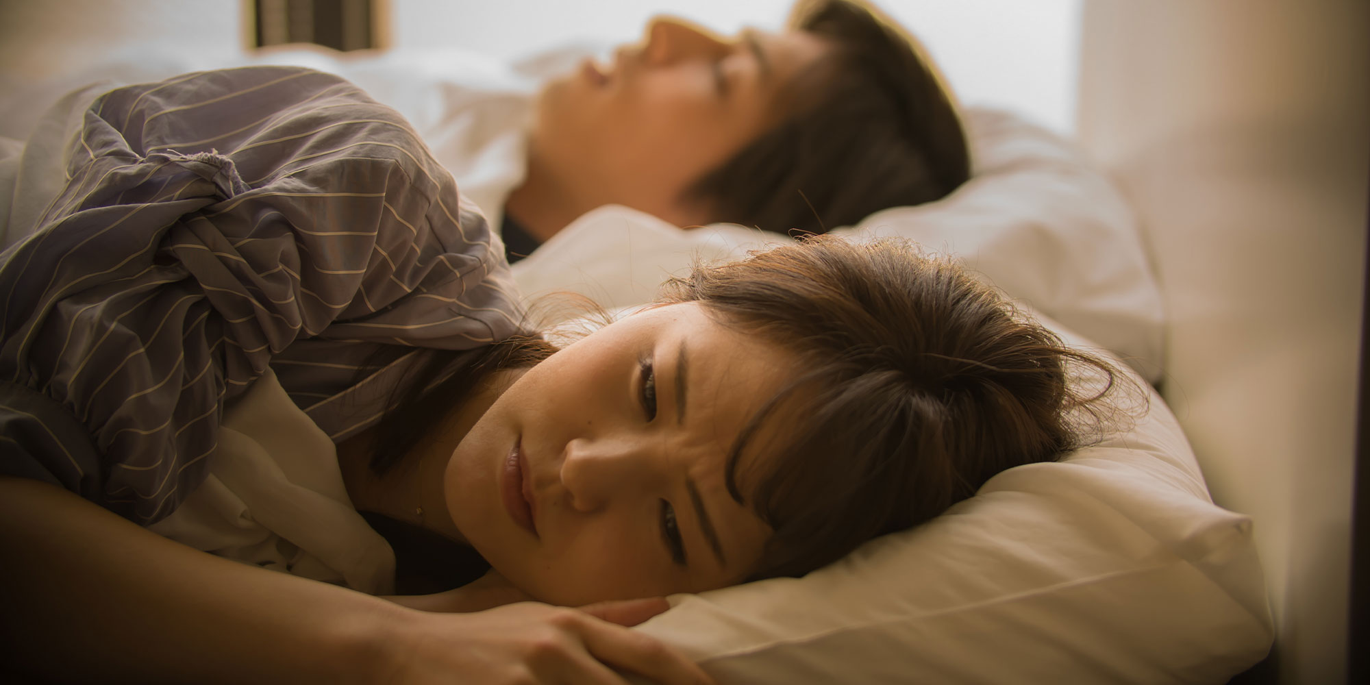 眠る男性と眠れない女性