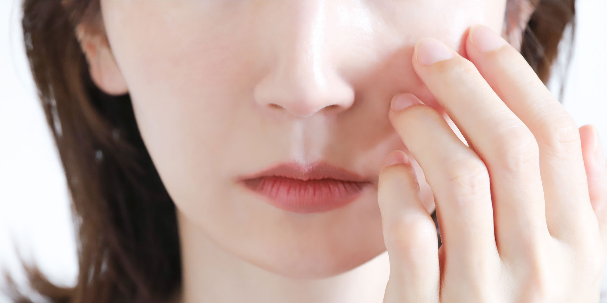 目の下を抑える女性