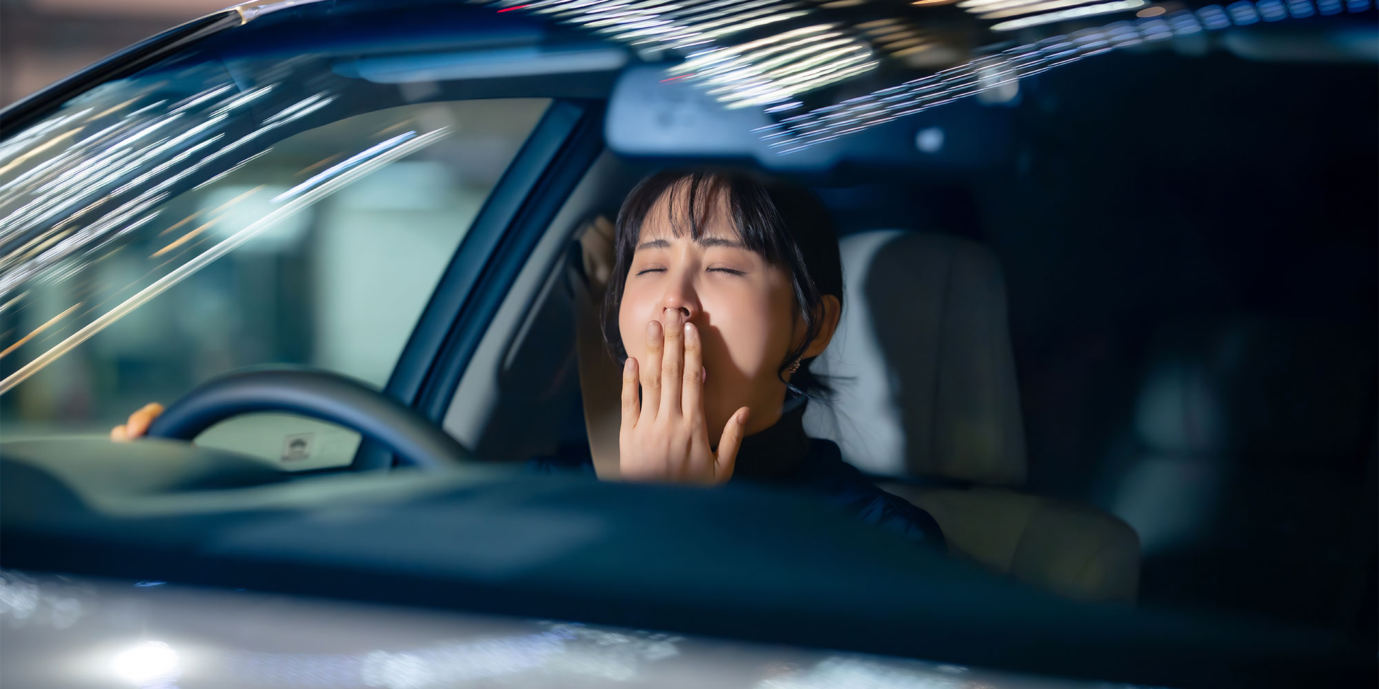 運転中の寝不足の女性