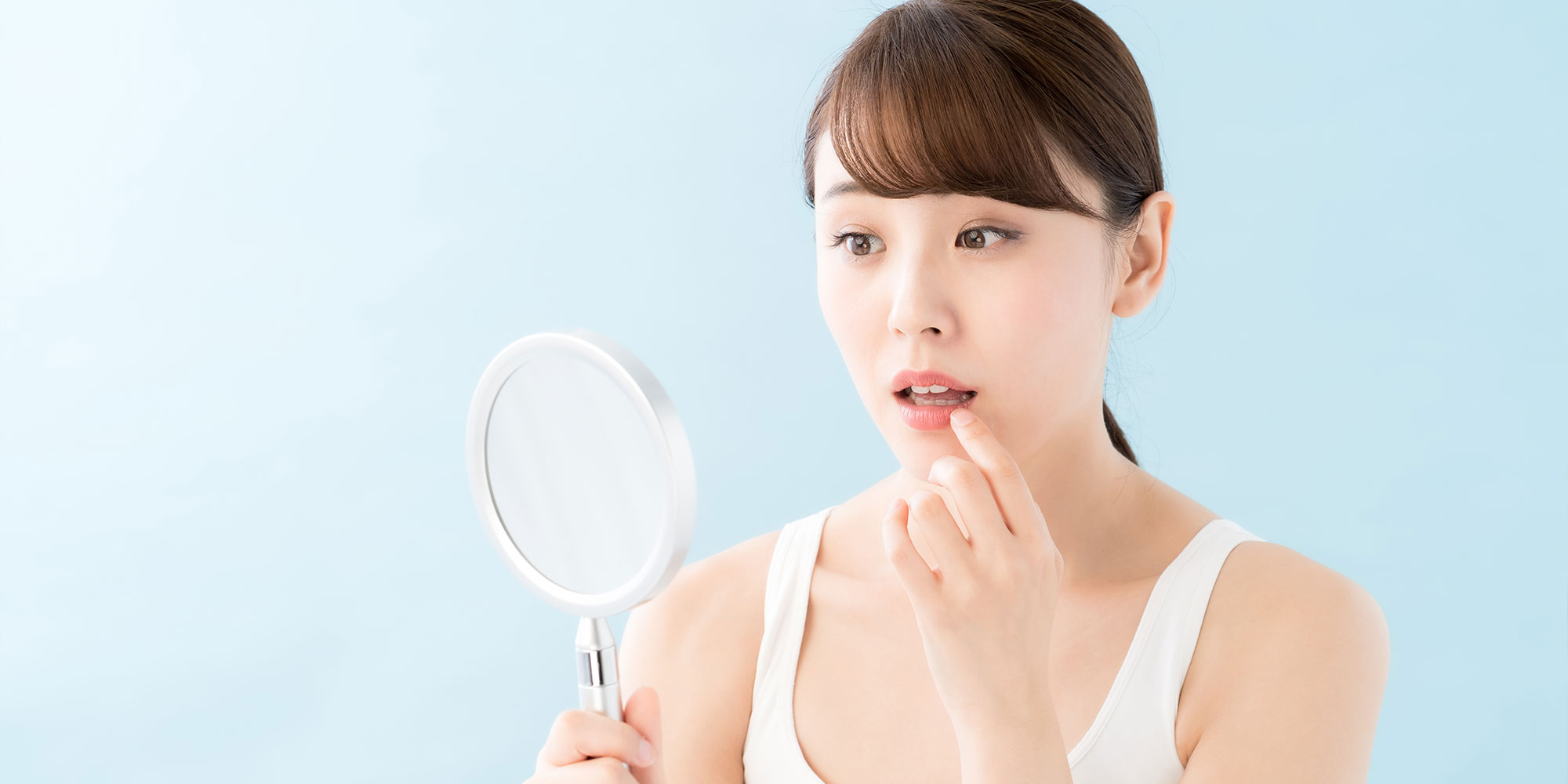 鏡を見て驚く女性