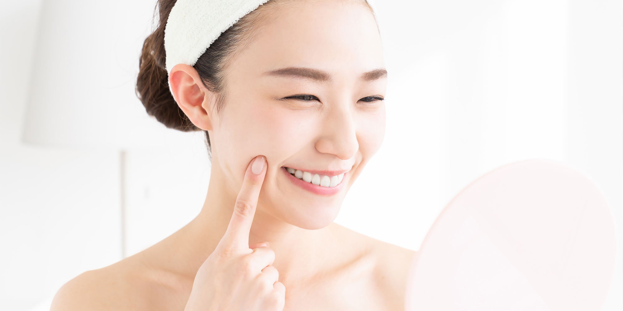 笑顔で鏡を見る女性