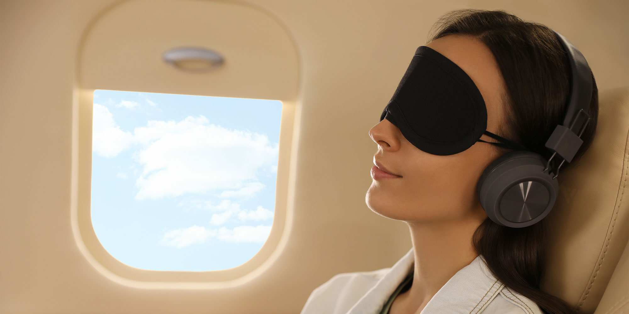 飛行機でアイマスクをする女性
