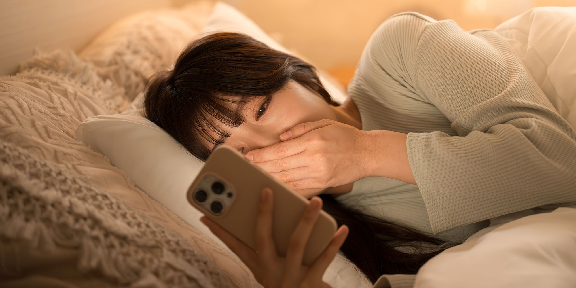 寝る前にスマホを見る女性